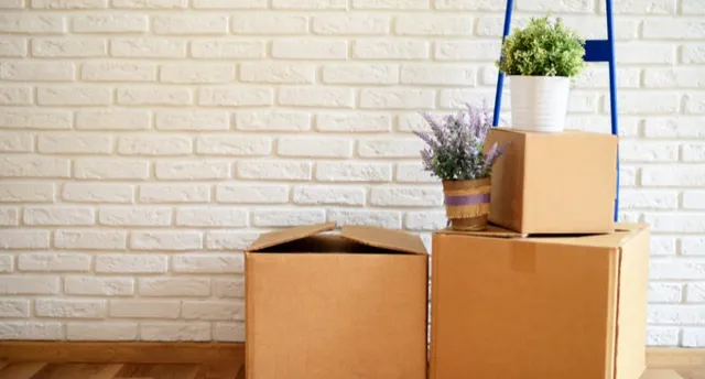 Moving boxes in a military family's new home, reflecting fewer PCS moves and long-term housing decisions
